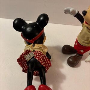 May include: Vintage Minnie Mouse figurine, black with a red polka dot skirt, red shoes, and a red headband. The figurine is wearing a yellow top. Mickey Mouse is also visible in the image.