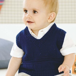 May include: A baby boy wearing a navy blue knitted vest with a white button-down shirt underneath. The vest has a V-neck and a cable knit pattern.