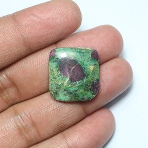 May include: A green and pink gemstone cabochon with a square shape. The gemstone has a swirling pattern of green, pink, and white.