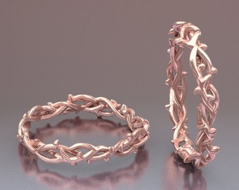 Puede incluir: Dos anillos de oro rosa con un diseño de vid espinosa. Los anillos están apilados uno encima del otro.