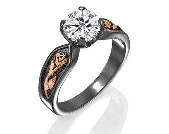 May include: A black and rose gold engagement ring with a single round diamond and a rose design on the band.