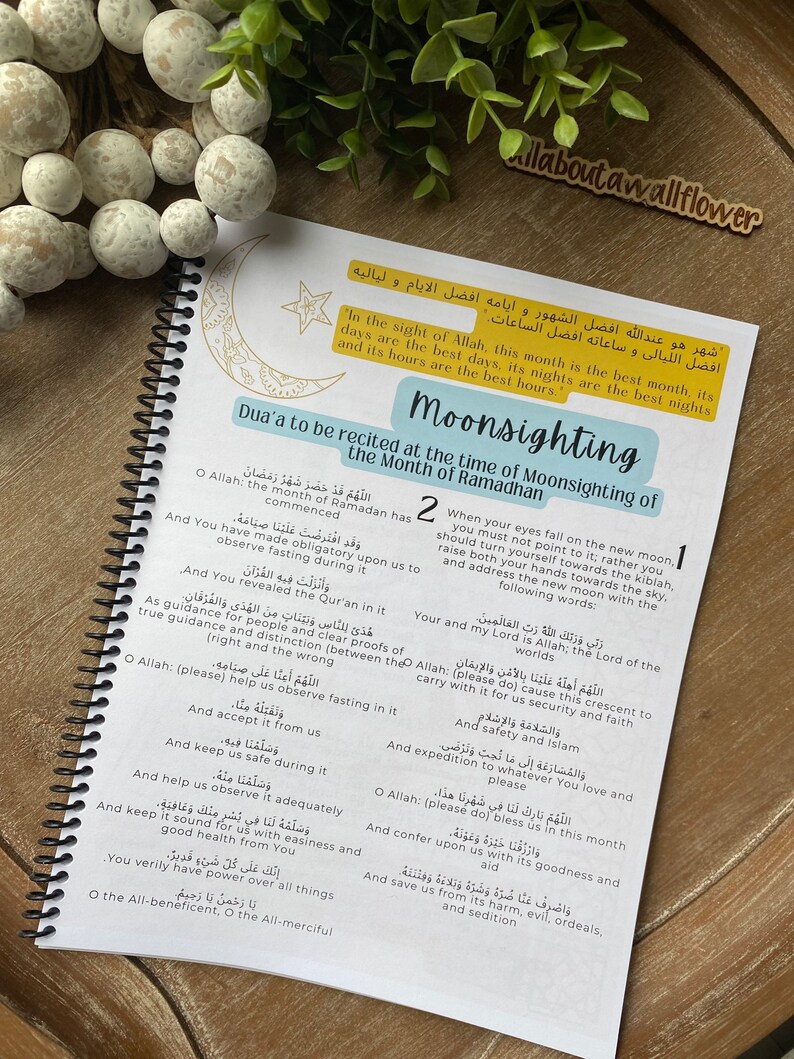 May include: A page from a book with a blue and yellow design. The page features a dua, or Islamic prayer, to be recited at the time of moon sighting for the month of Ramadan. The dua is written in Arabic and English. The page also includes a crescent moon and star graphic.