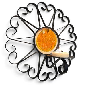 Peut inclure: Une applique murale en m&eacute;tal noir dot&eacute;e d'un cadre circulaire avec des volutes d&eacute;coratives rayonnantes. Au centre, un disque en verre ambr&eacute; translucide avec trois motifs circulaires en relief est suspendu, accompagn&eacute; d'un petit bougeoir.