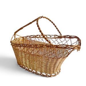 Puede incluir: Una cesta de alambre en tono dorado con una construcci&oacute;n de metal tejido, base rectangular y lados redondeados. La cesta incluye un asa de alambre trenzado fijada al borde superior, creando un dise&ntilde;o abierto con un patr&oacute;n de rejilla.