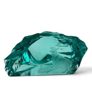 Peut inclure: Une sculpture en verre bleu sarcelle translucide avec une forme irr&eacute;guli&egrave;re rappelant un rocher. &Agrave; l'int&eacute;rieur du verre, une gravure blanche givr&eacute;e et d&eacute;taill&eacute;e repr&eacute;sente un lynx debout, la gueule ouverte comme s'il rugissait.