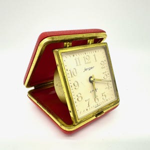 Réveil de voyage vintage Jerger - Horloge mécanique 2 rubis dans un boîtier pliable rouge, fabriqué en Allemagne