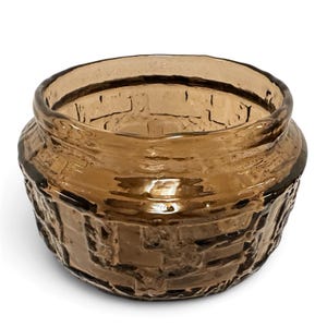 May include: A round, amber-colored glass bowl featuring a textured, raised geometric pattern on its exterior surface. The glass has a translucent quality, and the rim is smooth and slightly flared, creating a wide opening for the vessel.