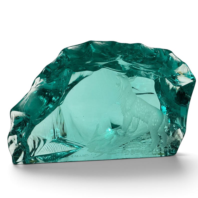 Peut inclure: Une sculpture en verre bleu sarcelle repr&eacute;sentant un loup sculpt&eacute; &agrave; la finition givr&eacute;e, debout sur une b&ucirc;che &agrave; l'int&eacute;rieur d'une structure en forme de grotte. L'ext&eacute;rieur du verre pr&eacute;sente une surface lisse, irr&eacute;guli&egrave;re et translucide.