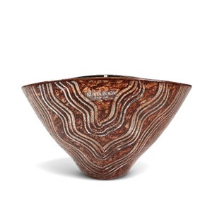May include: A wide, conical glass bowl featuring a deep brown, mottled, and textured surface with prominent, raised silver-colored wavy lines running vertically. The bowl displays the white text KOSTA BODA SINCE 1742 on the upper front section.