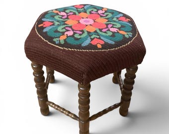 Banquinho vintage de madeira com bordado floral.