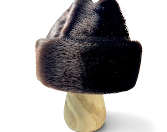 May include: A dark brown fur hat with a structured, rounded crown and a wide, folded brim. The dense, short-pile fur features a glossy texture with subtle variations in color, ranging from deep espresso to lighter chocolate brown tones throughout.