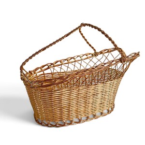 Puede incluir: Una cesta de alambre en tono dorado met&aacute;lico con una base tejida y una secci&oacute;n superior de celos&iacute;a abierta. La cesta tiene un asa de alambre trenzado unida a los lados, con una silueta curva y alargada dise&ntilde;ada para sostener una botella.