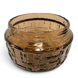 May include: A round, amber-colored glass bowl featuring a textured, raised geometric pattern on its exterior surface. The glass has a translucent quality, and the rim is smooth and slightly flared, creating a wide opening for the vessel.