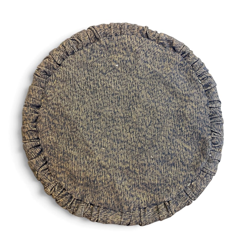 May include: A circular cushion featuring a dark charcoal gray fabric with a subtle gold-toned speckled texture. The edge of the cushion is finished with a gathered, pleated border made from the same dark gray and gold-flecked material.