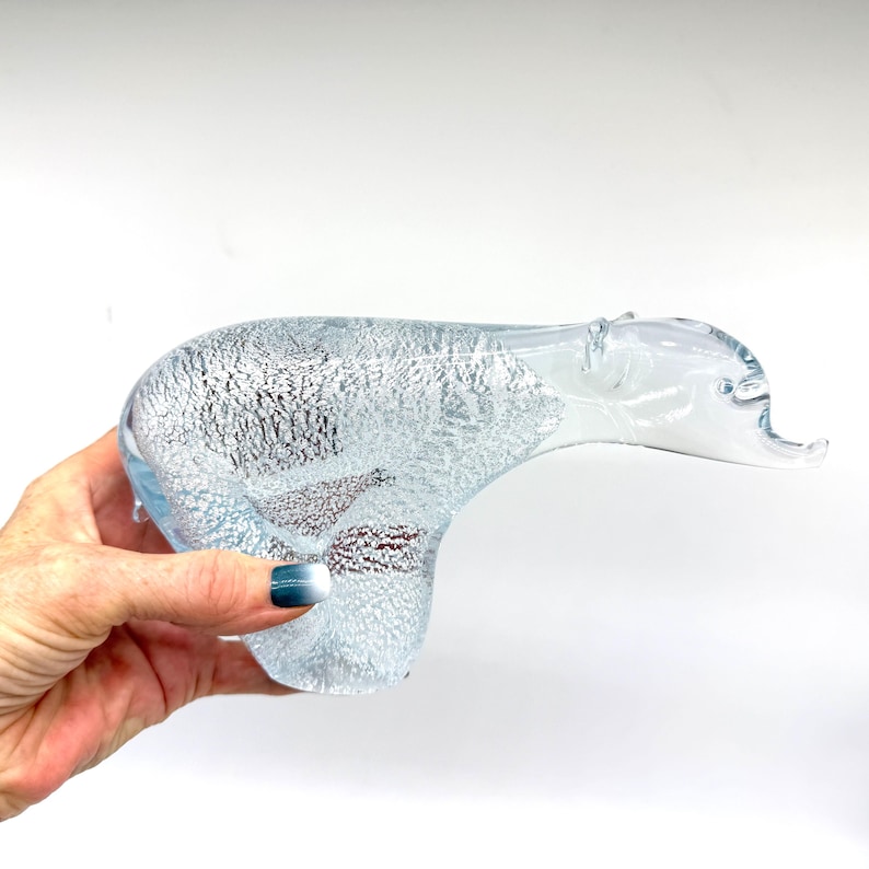 May include: A clear glass figurine shaped like a polar bear, featuring an internal textured pattern of white, bubbly, and silver-toned inclusions throughout the body, with a smooth, transparent head and snout extending forward.