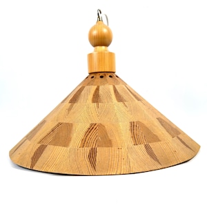 May include: A light brown, cone-shaped pendant lamp with a wooden grain pattern. The lamp has a rounded top and a decorative wooden ball at the top. The lamp is suspended by a metal hook.