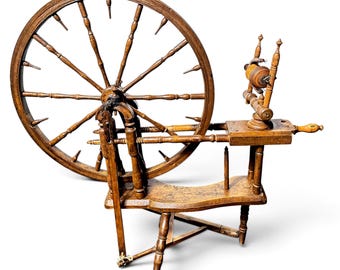May include: A brown wooden spinning wheel featuring a large circular wheel with numerous spokes, a horizontal bench, a vertical flyer assembly with a bobbin, and a tripod base. The structure is crafted from turned wood components throughout.