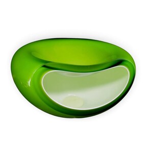 May include: A smooth, rounded glass bowl featuring a vibrant lime green exterior and a contrasting opaque white interior. The vessel has a wide, asymmetrical opening that curves inward, creating a deep, hollow basin with a polished finish.
