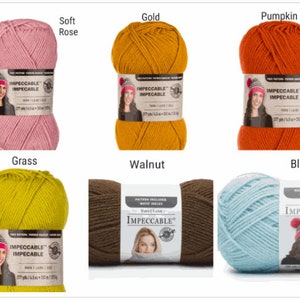 May include: A collection of Impeccable yarn skeins in various colors, including Soft Rose, Gold, Pumpkin, Grass, Walnut, and Blue Haze. Each skein is labeled with the brand name and yarn details. The yarn is 277 yards / 4.5 oz / 253 m / 127 g.