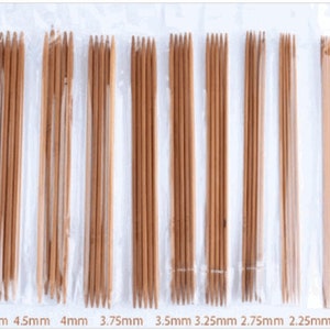 May include: Set of 10 bamboo knitting needles in various sizes, ranging from 2 mm to 5 mm. The needles are packaged in clear plastic and labeled with their size in millimeters.