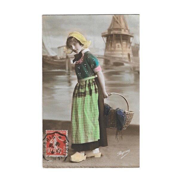 Fille hollandaise avec des chaussures en bois, carte postale photo antique teintée en couleur avec écriture manuscrite en langue française, cachet de la poste et timbre-poste de France