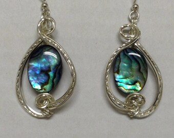 Peut inclure: Une paire de boucles d'oreilles en argent avec une coquille d'ormeau bleue et verte au centre de chaque boucle d'oreille.