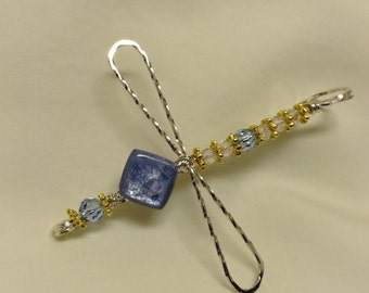 Peut inclure: Une libellule en fil d'argent avec une pierre précieuse bleue et des perles claires et dorées.