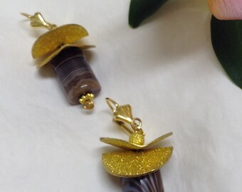 Peut inclure: Une paire de boucles d'oreilles dorées et brunes avec un design géométrique. Les boucles d'oreilles présentent un cadre en métal doré avec une finition dorée scintillante et une pierre d'agate brune avec des rayures blanches.