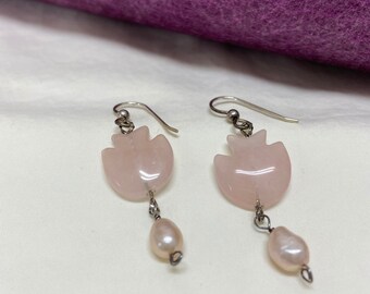 Peut inclure: Une paire de boucles d'oreilles avec des gouttes de quartz rose et de perle. Les boucles d'oreilles sont en argent et ont un design délicat.
