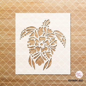 Pu&ograve; includere: Uno stencil bianco di una tartaruga con un disegno floreale. La tartaruga &egrave; rivolta a destra e ha un motivo floreale dettagliato sul suo guscio.