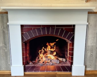 May include: White painted fireplace mantel with a brick surround and a realistic image of a fire burning inside.