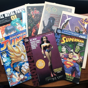 May include: A collection of comic books featuring characters like Superman, Wonder Woman, and others. The comics are from DC Comics and include the text "HOT TOYS AND COLLECTIBLES FROM DC DIRECT!" and "JUSTICE LEAGUE ANIMATED MAQUETTE STATUE".