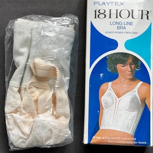 May include: A white Playtex 18 Hour long line bra with lace cups and stretch straps, packaged in a clear plastic bag next to its original cardboard box. The box features the text 18 Hour Long Line Bra, 220, 40 C, and White, with an illustration.