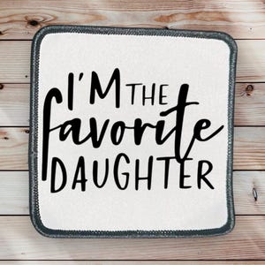 May include: White square patch with black text that reads "I'm the favorite daughter".