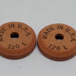 May include: Two brown sanding discs with a hole in the center. The discs are labeled "MADE IN U.S.A." and "120 L".