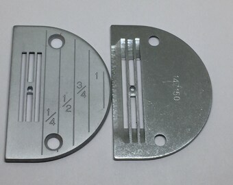 May include: Two silver sewing machine presser feet with a measurement guide on one foot. The foot on the left has markings for 1/4 inch, 1/2 inch, 3/4 inch, and 1 inch. The foot on the right has the number 147150 printed on it.