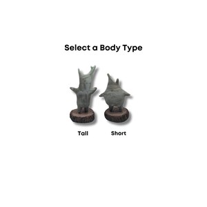 May include: Two ceramic figurines, one tall and one short, with a green and white glaze. The figurines are standing on wooden bases. The text "Select a Body Type" is above the figurines. The tall figurine is labeled "Tall" and the short figurine is labeled "Short".