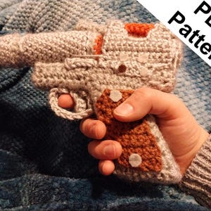 Può includere: Uno schema a uncinetto per una pistola, con uno schema di colori marrone e beige. Lo schema è disponibile per il download in PDF.