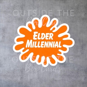 May include: A sticker with the text "ELDER MILLENNIAL" in white, set against an orange splash design with a white outline. The sticker is on a gray background.