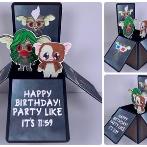 May include: A pop-up card with a black background and a white border. The card features a 3D pop-up of two green and brown creatures with the text "HAPPY BIRTHDAY! PARTY LIKE IT'S 11:59" on the front.