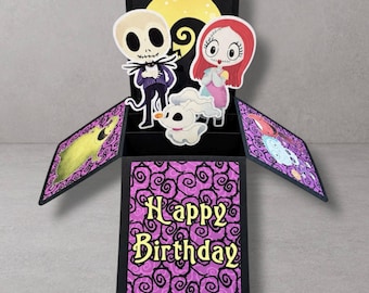 May include: A pop-up greeting card featuring a black box base with purple swirl patterns and the text Happy Birthday. Inside are die-cut figures of a skeleton character, a red-haired character, and a white ghost dog against a yellow moon background.