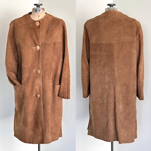 May include: A long brown suede coat with a button-up front and pockets. The coat is on a white mannequin.