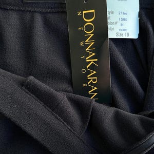 Pode incluir: Uma saia preta Donna Karan New York com fecho de correr e uma etiqueta de tamanho 10. A etiqueta inclui o n&uacute;mero de estilo 2166, o n&uacute;mero de lote 1580 e a cor preta.