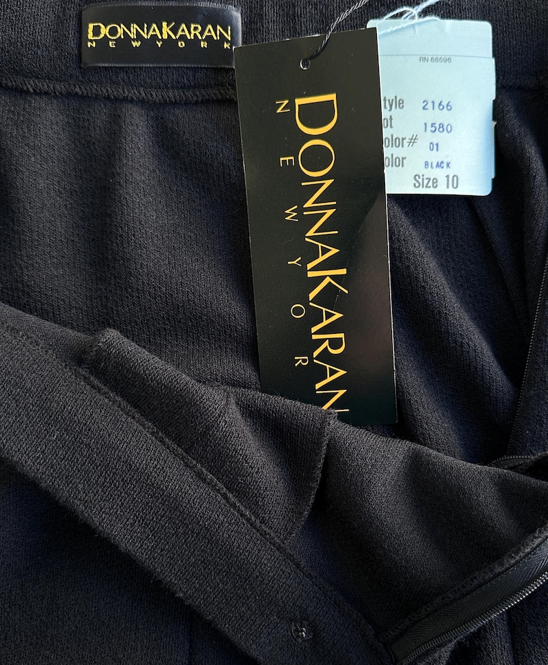 Pode incluir: Uma saia preta Donna Karan New York com fecho de correr e uma etiqueta de tamanho 10. A etiqueta inclui o n&uacute;mero de estilo 2166, o n&uacute;mero de lote 1580 e a cor preta.