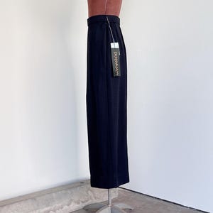 Pode incluir: Uma saia maxi preta com silhueta reta. A saia &eacute; feita de um tecido liso e leve e tem um design simples e elegante. A saia est&aacute; em um manequim e tem uma etiqueta que diz "Donna Karan".