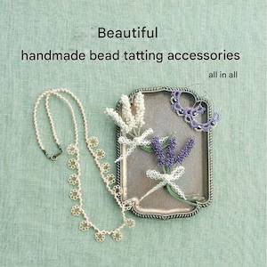 Puede incluir: Colección de accesorios de tatting de cuentas hechos a mano, que incluyen un collar con detalles florales, pendientes y ramitas decorativas en una bandeja plateada. La imagen incluye el texto "Beautiful handmade bead tatting accessories all in all."