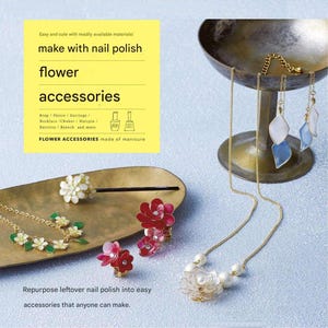 May include: A collection of flower accessories made from nail polish, including rings, earrings, necklaces, and hairpins. The accessories are in various colors, including white, red, and blue, and are displayed on a gold-colored tray and stand. Text on the image reads "make with nail polish flower accessories."