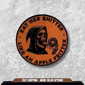 May include: Round orange patch with black text and a Grim Reaper graphic. The text reads "EAT HER SHITTER LIKE AN APPLE FRITTER." The Grim Reaper is depicted with a skull and is licking a donut. The patch has a leather-like texture.