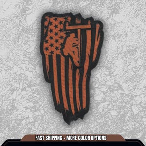 May include: A patch featuring a fist design with an American flag motif. The flag is rendered in orange and black, with stars and stripes. The patch also includes a silhouette of a person. The text at the bottom reads "FAST SHIPPING - MORE COLOR OPTIONS."