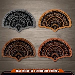 May include: Four fan-shaped heat activated leatherette patches featuring a black turkey tail feather design. The patches are arranged in a grid, with one gray, one light tan, one medium brown, and one dark brown patch, all with black details.